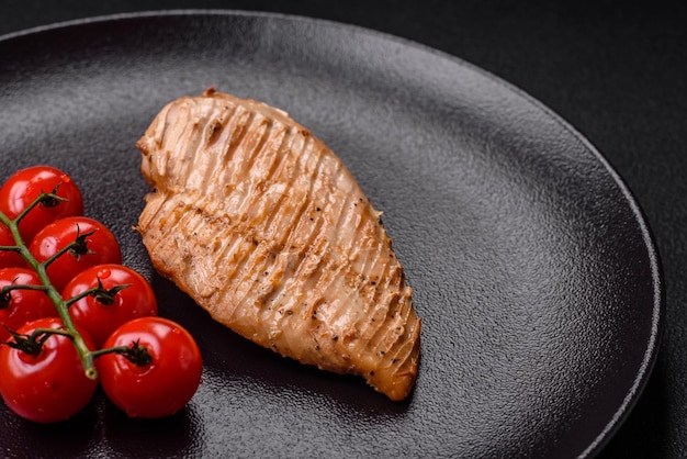 Photo délicieux filet de poulet grillé juteux avec des épices salées et des herbes sur un fond de béton sombre