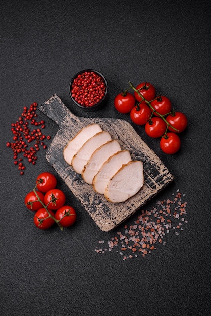 Délicieux filet de poulet grillé juteux avec des épices salées et des herbes sur un fond de béton sombre