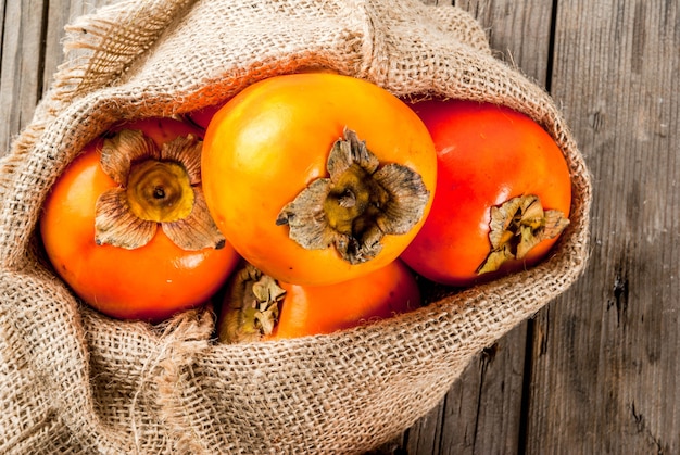 Photo délicieux fruits kaki mûrs crus sur un sac