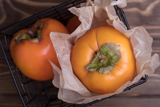 Délicieux fruits de kaki orange frais sur table en bois