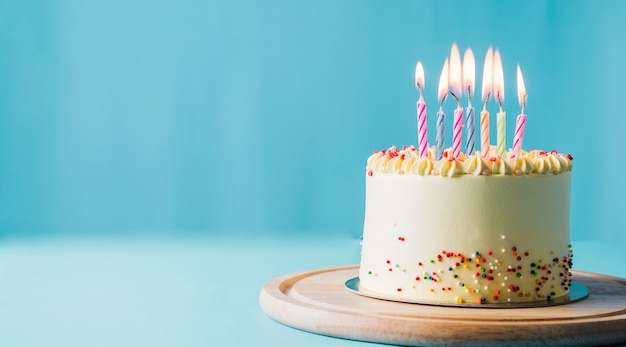 Délicieux gâteau d'anniversaire avec bougie sur fond bleu clair. Espace pour le texte