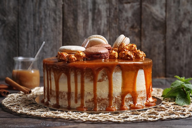 Un délicieux gâteau au caramel sur une serviette en osier contre un mur en bois.