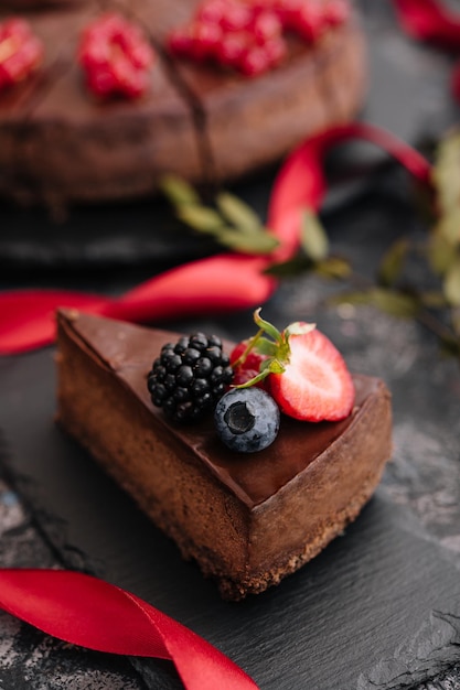 Délicieux gâteau au chocolat décoré de baies fraîches sur une table en bois