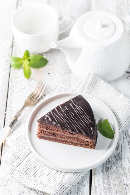 Délicieux gâteau au chocolat Prague sur plaque sur fond blanc