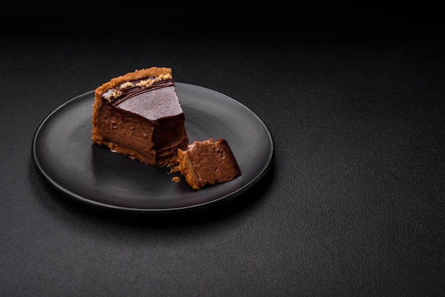 Délicieux gâteau au chocolat sucré frais avec des noix coupées en tranches sur un fond en béton foncé