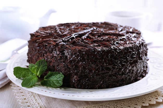 Délicieux gâteau au chocolat avec une tasse de thé sur la table en gros plan