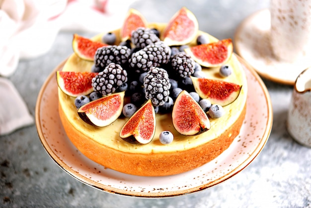 Délicieux gâteau au fromage fait maison avec des figues fraîches et des bleuets et des mûres surgelés. Cuisson saine.