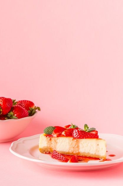 Délicieux gâteau au fromage fait maison avec des fraises sur rose.