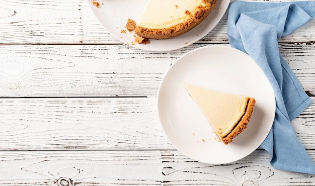 Délicieux gâteau au fromage fait maison sur une table en bois blanche