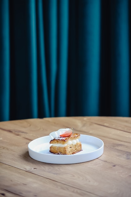 Délicieux gâteau aux fraises avec crème fouettée sur table en bois. Mille feuille de fraises.