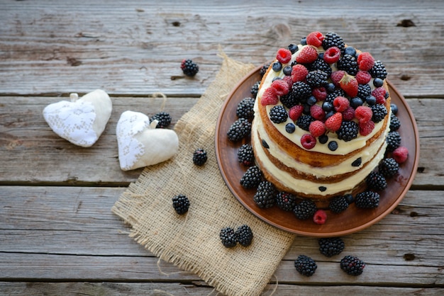 Délicieux gâteau aux fraises, framboises et mûres sur une table en bois