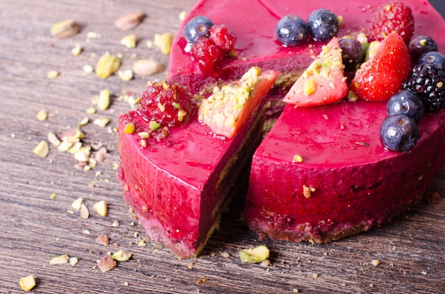 Délicieux gâteau aux framboises avec fraises fraîches, framboises, myrtilles, cassis et pistaches