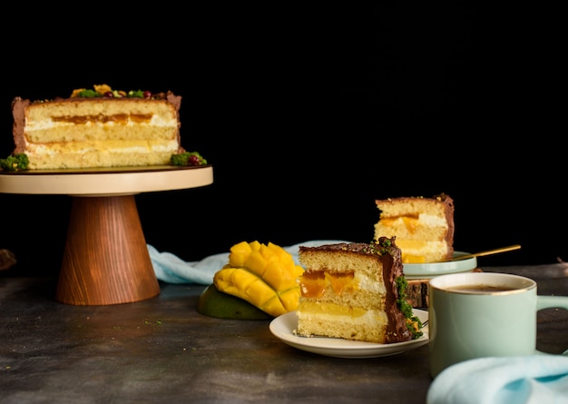 Délicieux gâteau dans la coupe, un morceau de gâteau avec une couche de mangue, fruit de la passion, crème à la vanille, biscuit.