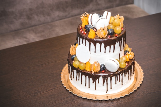 Délicieux gâteau avec décoration de fruits et de baies sur table en bois