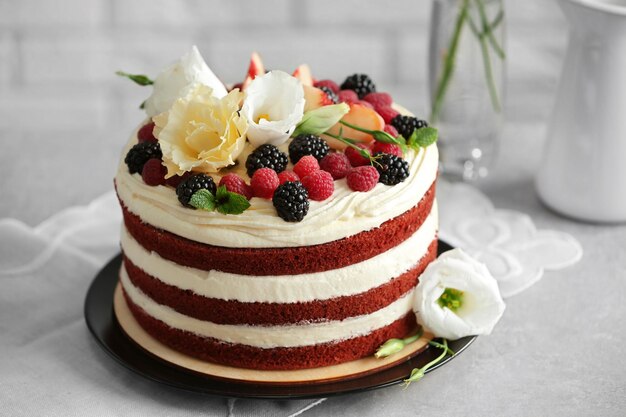 Délicieux gâteau à la décoration de fruits et de baies sur table grise