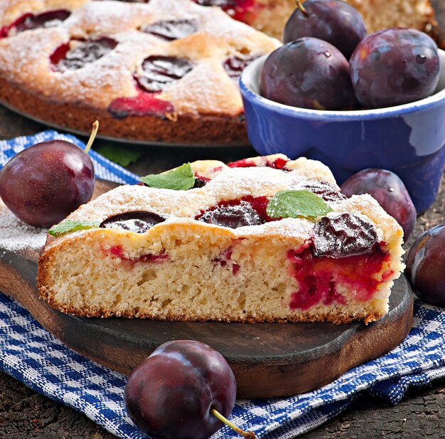 Délicieux gâteau fait maison avec des prunes sur un fond en bois