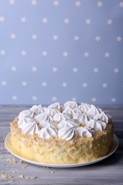 Délicieux gâteau de meringue maison sur table en bois sur fond bleu