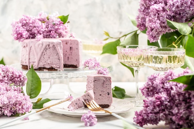 Délicieux gâteau mousse aux baies avec du vin de champagne prosecco bouquet de lilas en fleurs pourpres cuisine française fond de carte postale