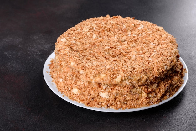 Délicieux gâteau napoléon frais avec de la crème sur une surface sombre. Gâteau composé de cordes et de crème