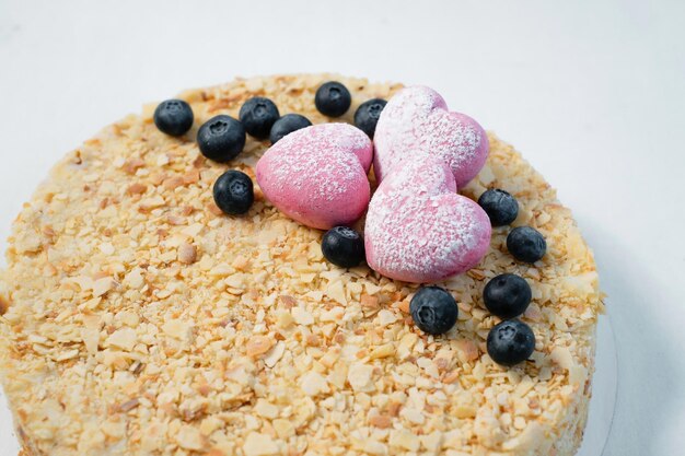 Délicieux gâteau avec des noix de mûre fraîches et des coeurs roses sur le tableau blanc se bouchent