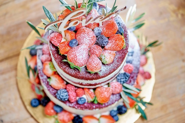 Délicieux gâteau nu de mariage aux fraises et fruits rouges vu d'en haut, pour mariage, saint valentin ou anniversaire.