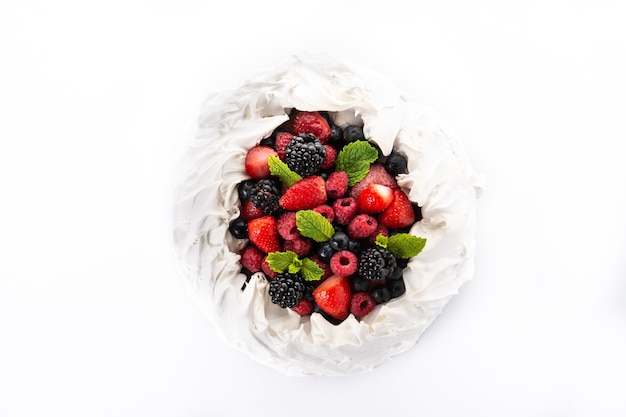 Délicieux gâteau Pavlova avec meringue surmontée et baies fraîches isolées sur fond blanc