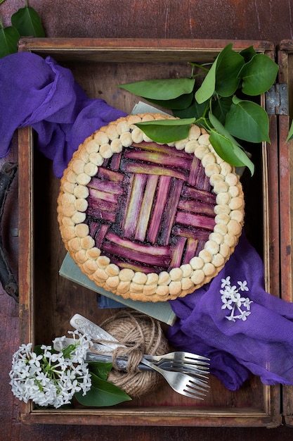 Délicieux gâteau à la rhubarbe fait maison avec des myrtilles sur un fond sombre