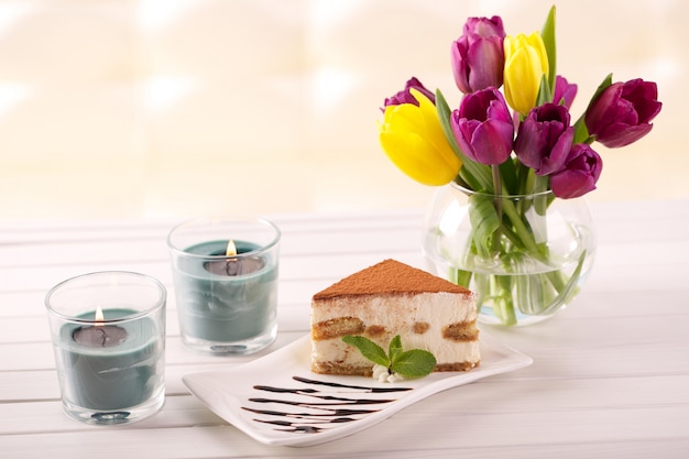 Délicieux gâteau tiramisu et fleurs de tulipes en cadeau