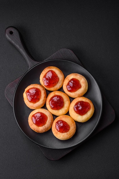 De délicieux gâteaux au fromage cottage frais avec des raisins secs et de la vanille sur une plaque en céramique noire