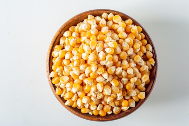 Délicieux grains de maïs jaune organique crus grains de pop-corn à l'intérieur d'un sac de coton rustique isolé