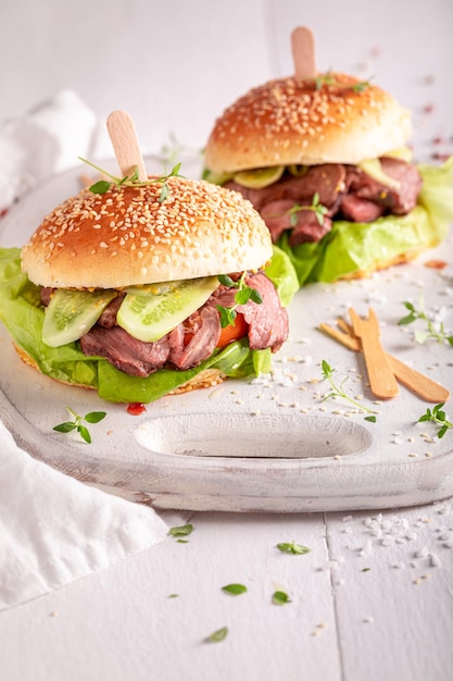 Délicieux hamburger avec cornichons et bœuf assaisonné rôti