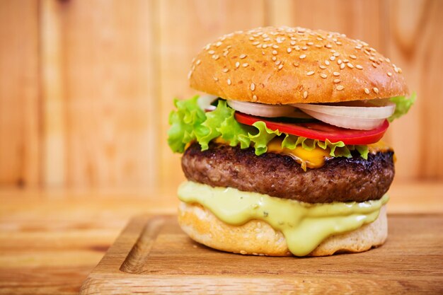 Photo délicieux hamburger fait à la main sur fond de bois vue rapprochée