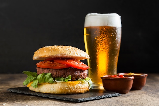 Photo délicieux hamburger avec verre de bière et sauce ketchup