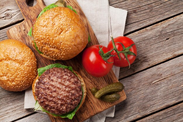 Délicieux hamburgers faits maison grillés cuisinant avec du bœuf, du fromage, de la tomate, du concombre et de la laitue Vue de dessus avec un espace pour votre texte