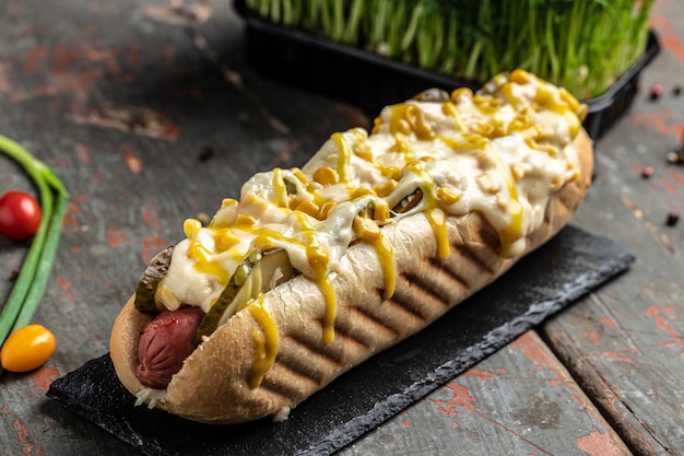 Délicieux hot-dog grillé dans un restaurant, saucisses faites maison enveloppées de hot-dogs avec du fromage et du maïs. bannière, menu, lieu de recette pour le texte, vue de dessus