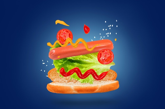 Délicieux hot-dog avec des ingrédients volants sur fond bleu Nourriture en lévitation