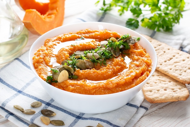 Délicieux houmous maison sain aux haricots avec citrouille au four, tahina et épices avec du pain plat sur fond clair