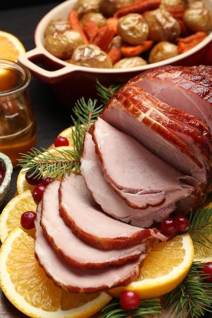 Un délicieux jambon au four servi sur une table en bois noir.