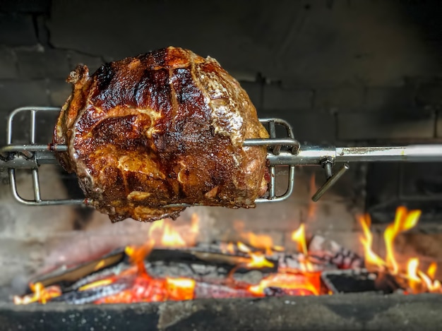 Délicieux jambons de porc cuits sur un feu ouvert. Griller le plat de viande, le porc rôti à la broche.