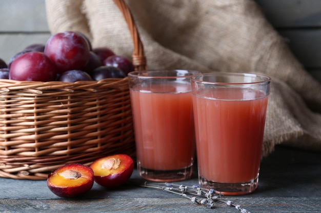 Délicieux jus de prune avec des fruits sur la table en gros plan