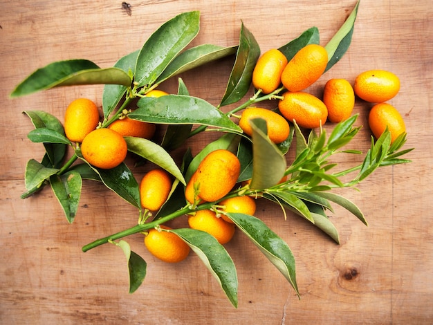 De délicieux kumquats orange sur une table en bois