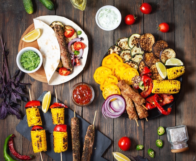 Photo délicieux légumes grillés et doner kebab sur un fond en bois