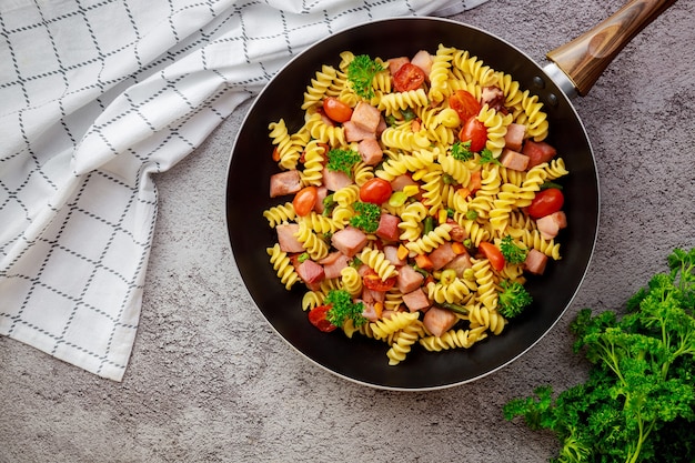 Délicieux macaronis aux légumes et jambon coupé. Vue de dessus.