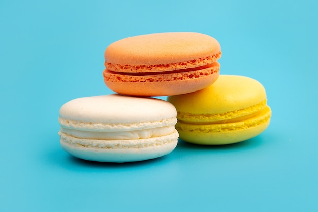 Délicieux macarons colorés sur fond bleu