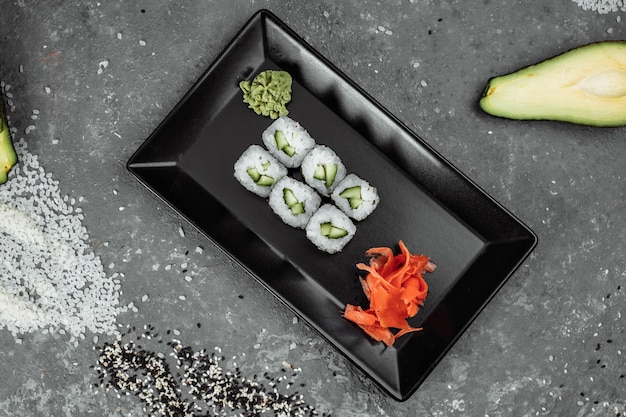Délicieux maki juteux et appétissants au concombre. Sushi sur fond gris.