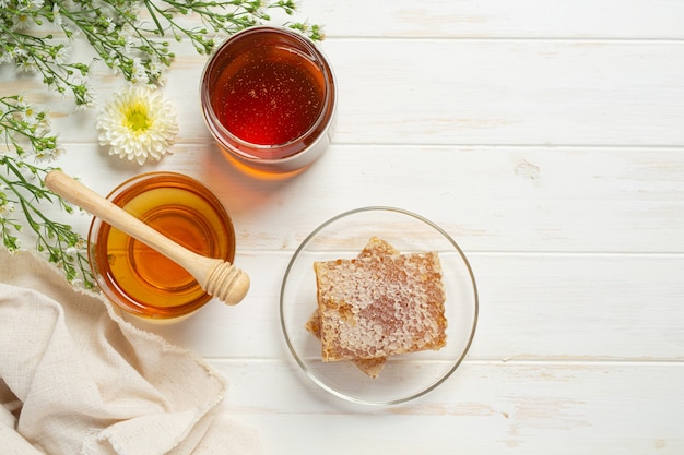 Délicieux miel sur une surface en bois blanche