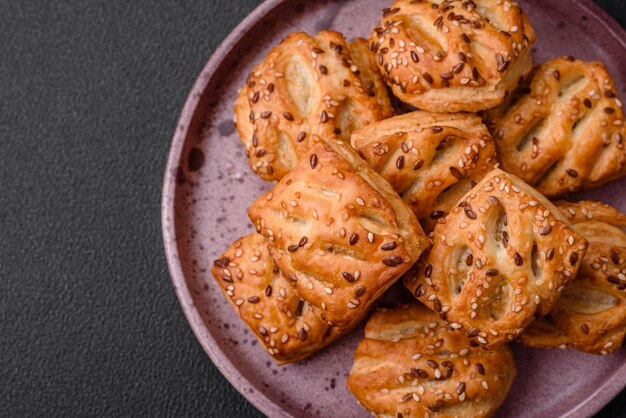 Délicieux mini choux croustillants avec saucisses ou viande au thym salé et sésame sur fond de béton foncé