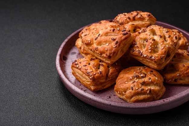 Délicieux mini choux croustillants avec saucisses ou viande au thym salé et sésame sur fond de béton foncé