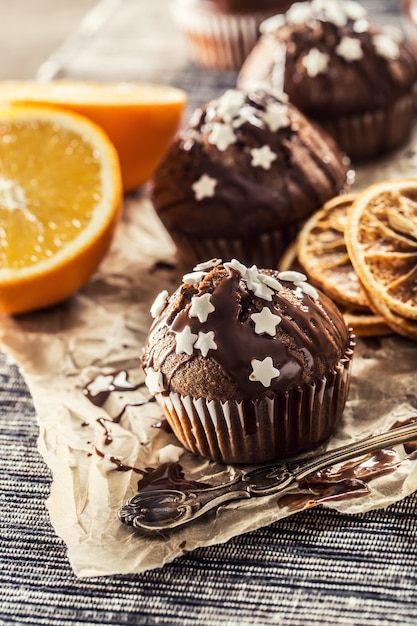 De délicieux muffins au chocolat de Noël saupoudrés de garniture et d'étoiles blanches.