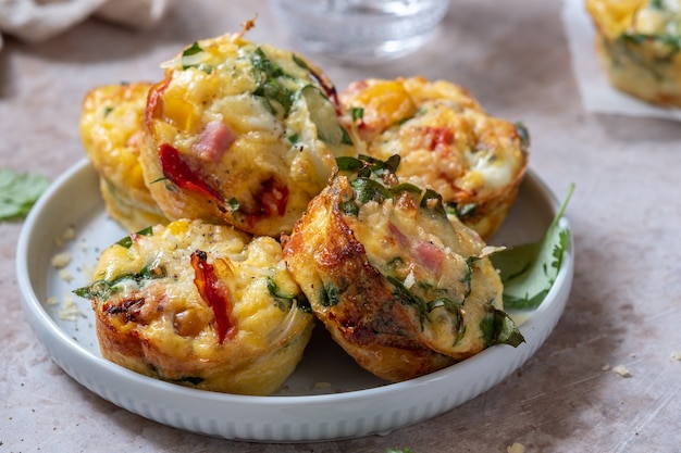 Délicieux muffins aux œufs avec jambon, fromage, épinards et légumes